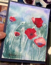watercolor painting of red poppies shown in artist's hand
