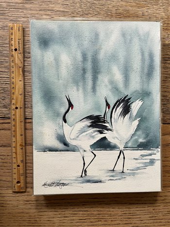 watercolor of 2 black & white cranes next to ruler for size reference
